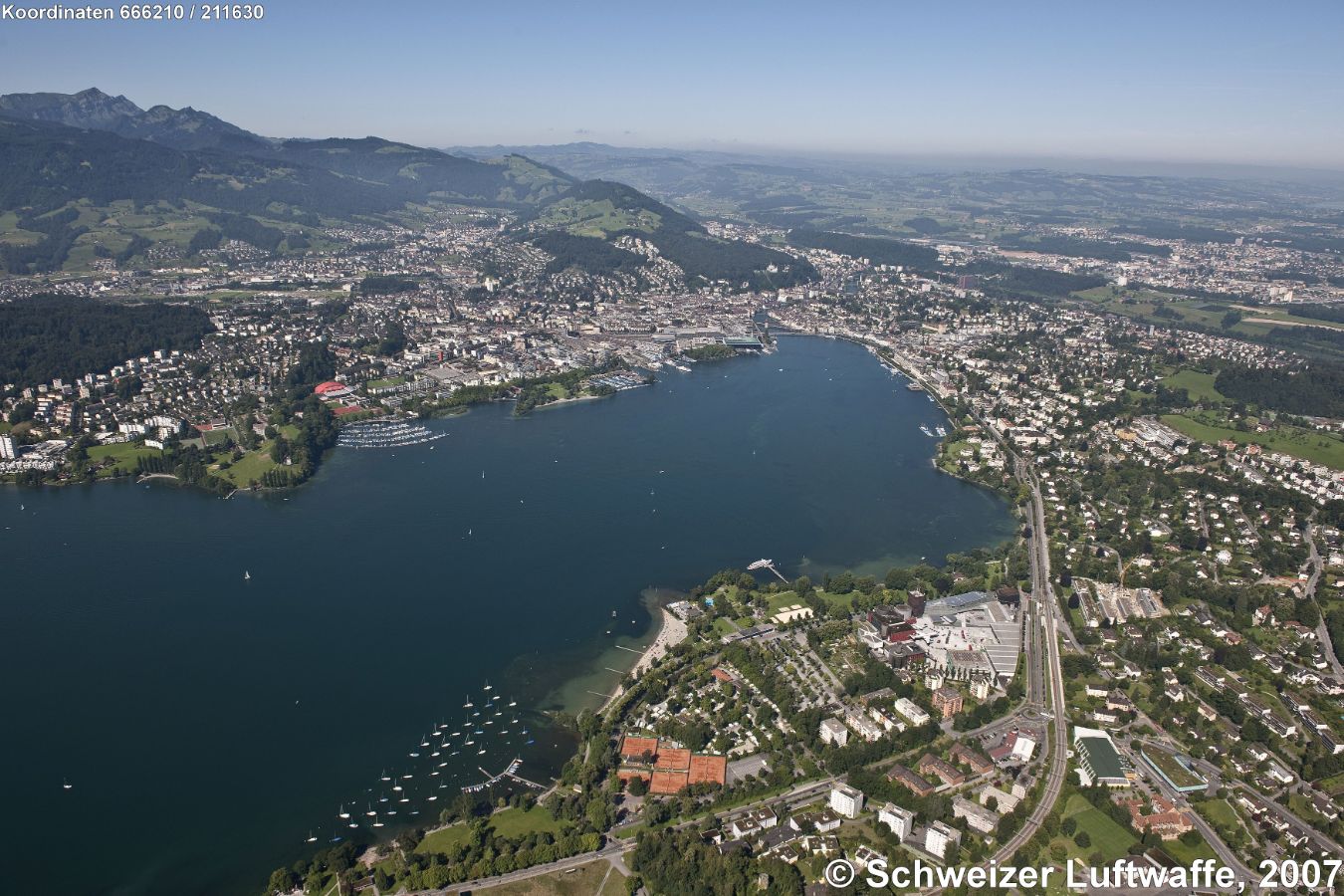 Luzern mit Vierwaldstättersee. Blickrichtung SW. Rechts unten im Vordergrund: Verkehrshaus der Schweiz (Position 2'668'209.46, 1'211'717.17); Stadt Luzern und Reuss (obere Bildmitte); Dorf am westlichen See-Ufer: Kriens; ganz links Bildmitte am See: Tribsche.